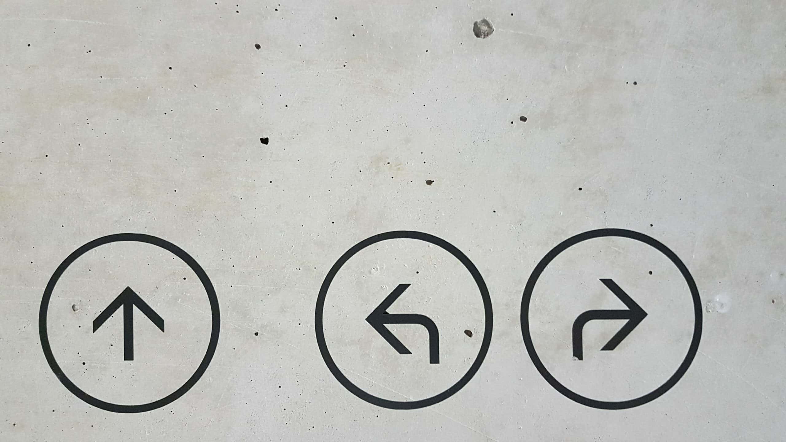 Image of 3 arrows pointing different directions on concrete for landing page blog