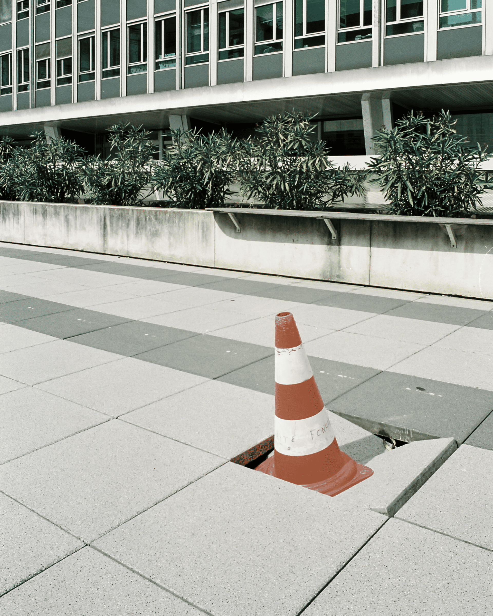 Orange cone on a cracked tile