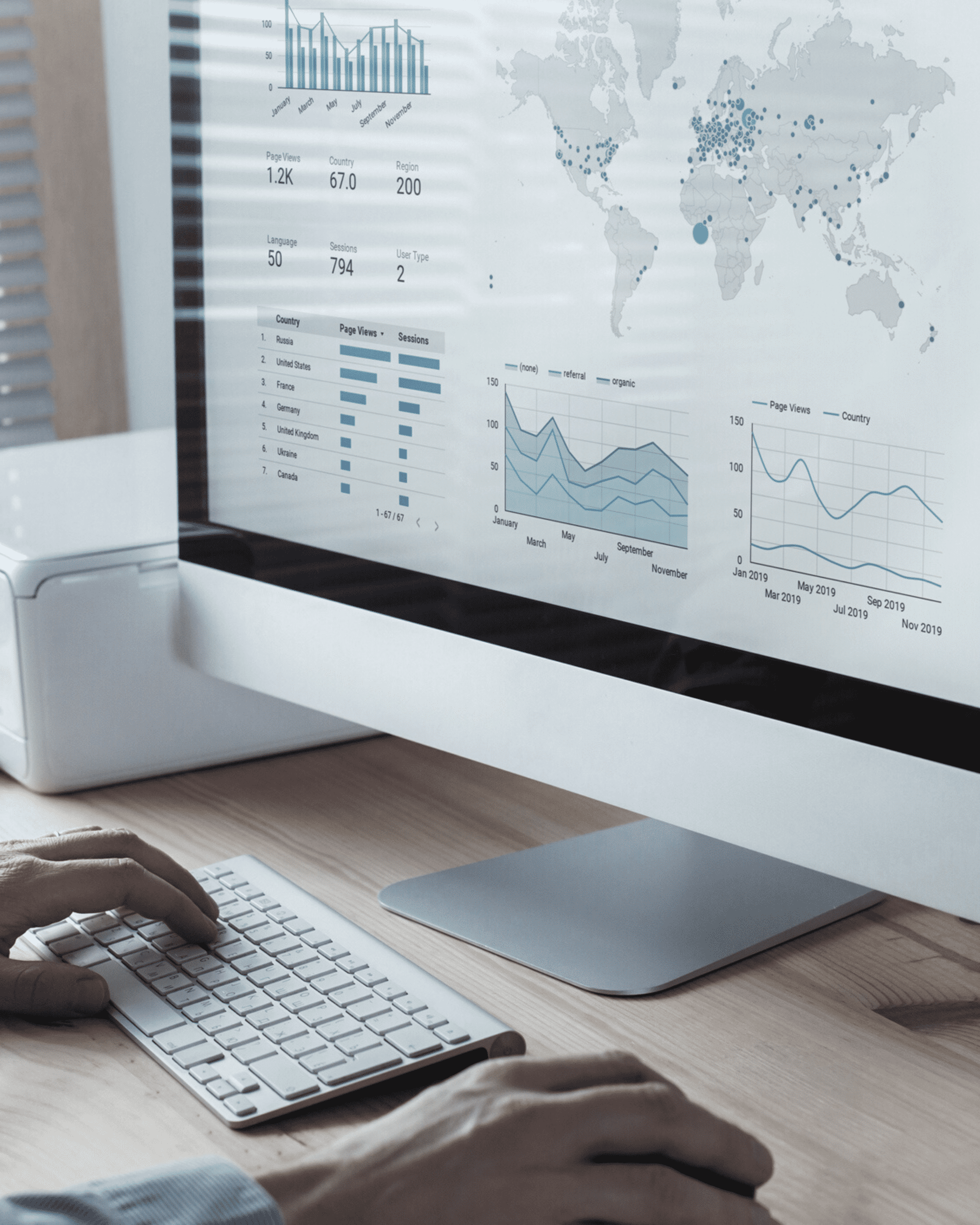 Hands on a keyboard while looking at a data analytics dashboard