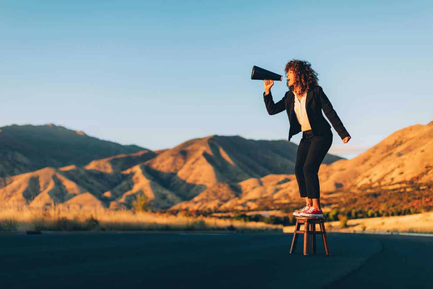 A businesswoman stands alone on a stool in a rural area of Utah shouting through a megaphone waiting to be heard. She is selling an idea that she believes will benefit her business and clients.