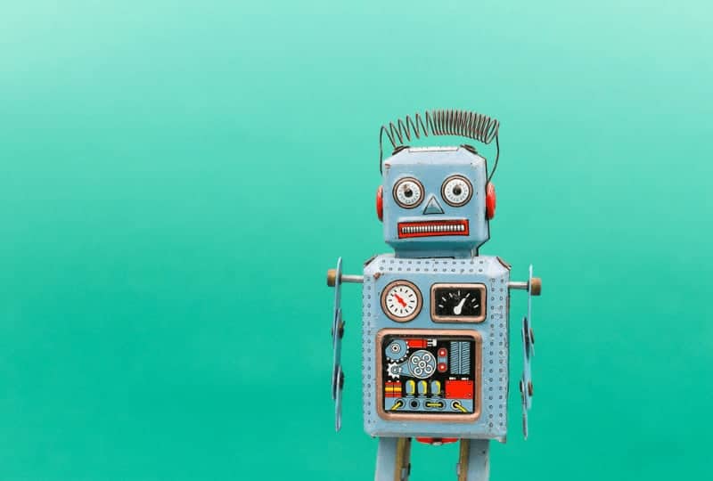 little windup robot in front of a green background