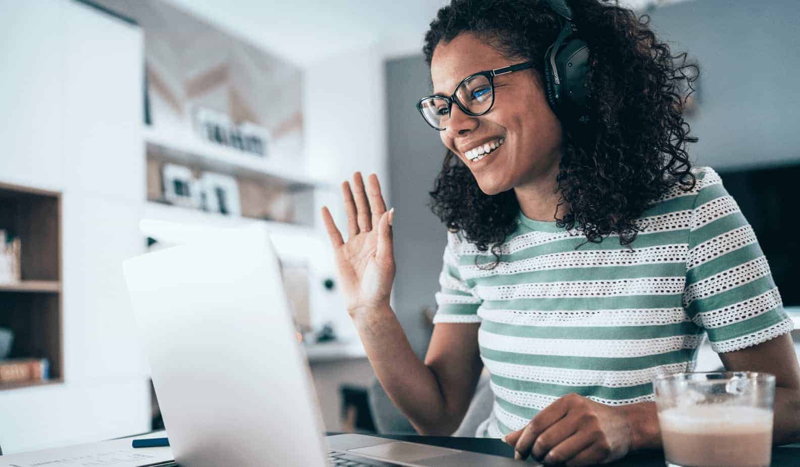 Woman on computer wearing headphones attending a webinar