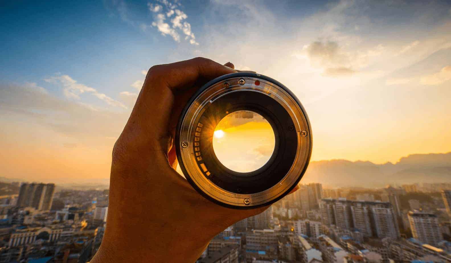 hand looking through a glass at a sunset