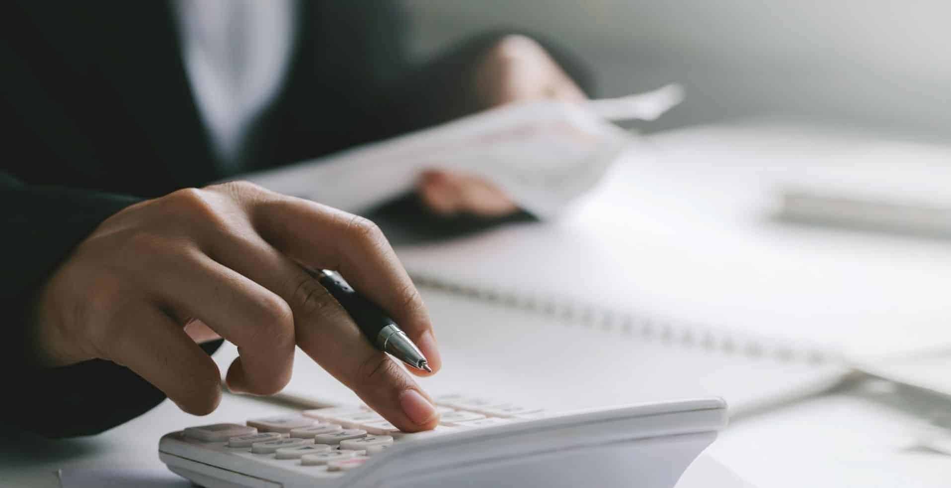 Person using a calculator while working at a desk