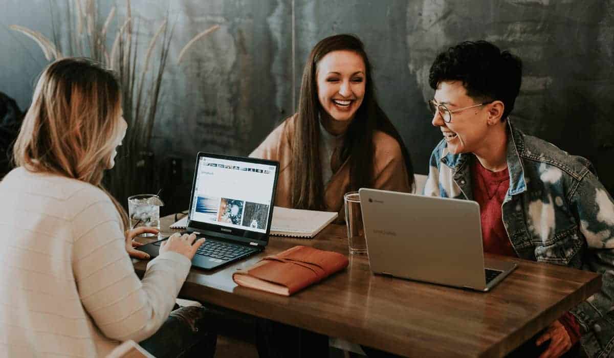 three people laughing around a table