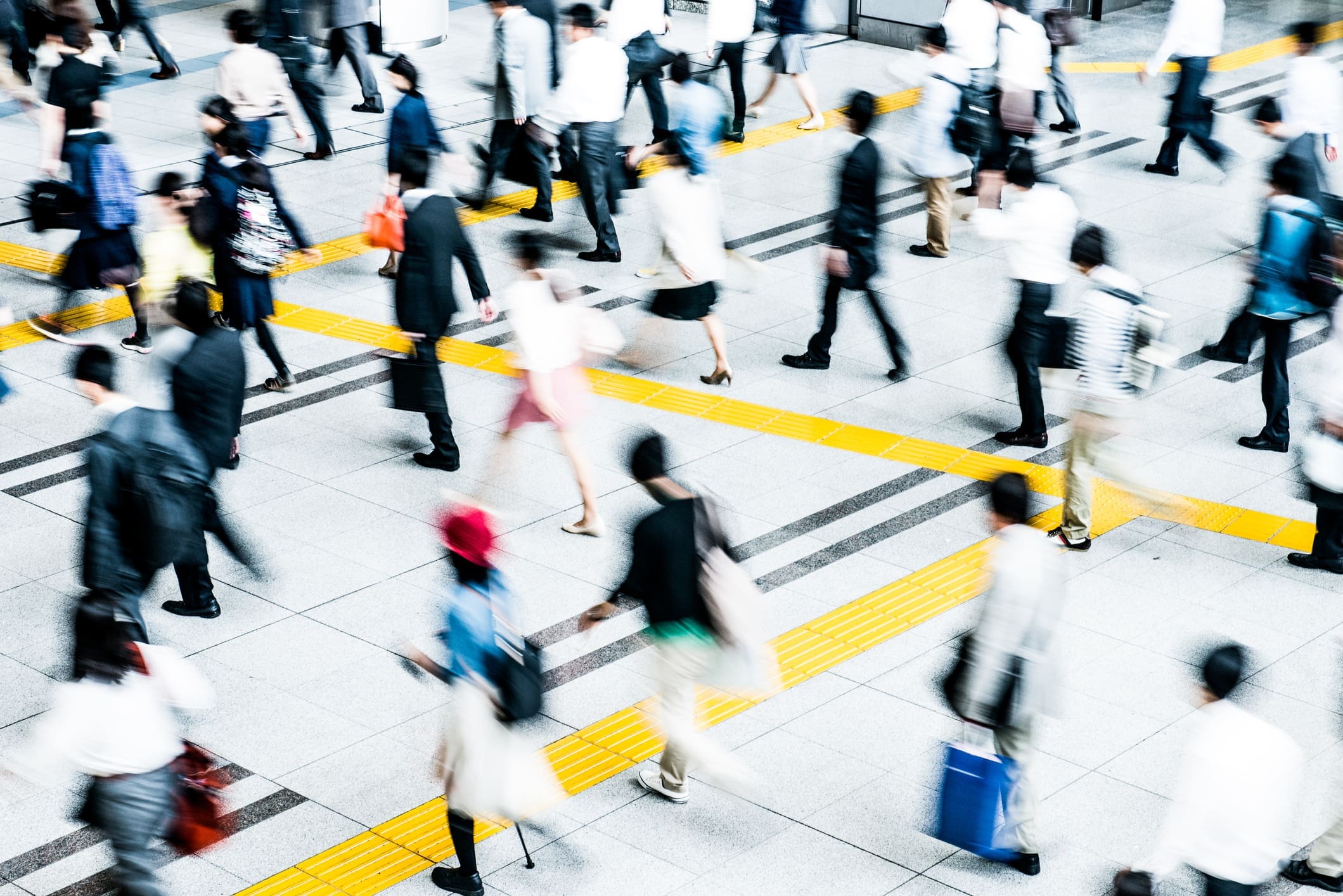 Many people crossing a large crosswalk