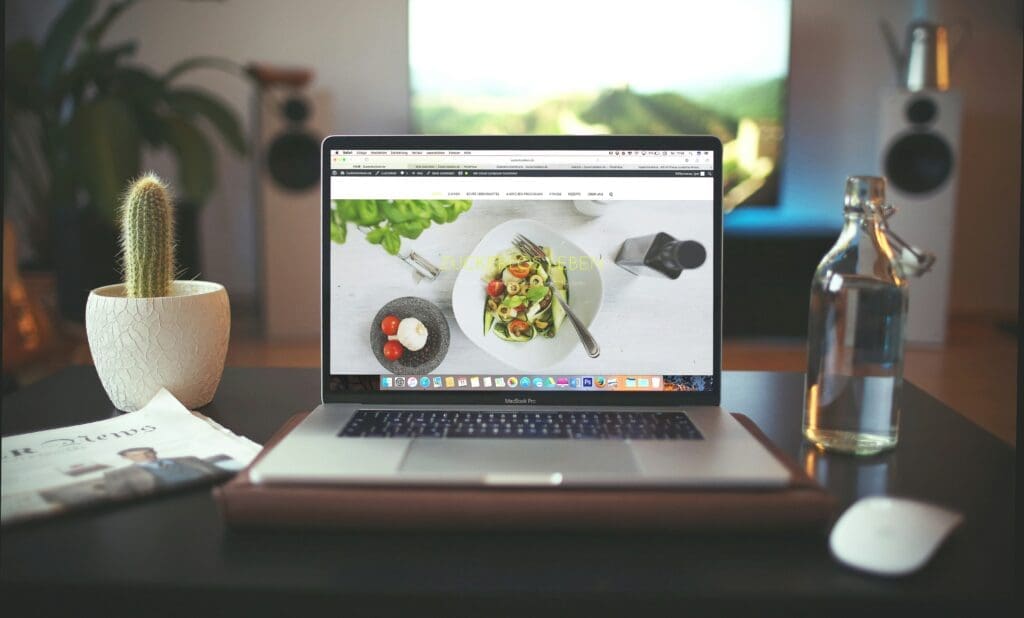 Laptop in an office with a wordpress website and picture of a salad on the screen