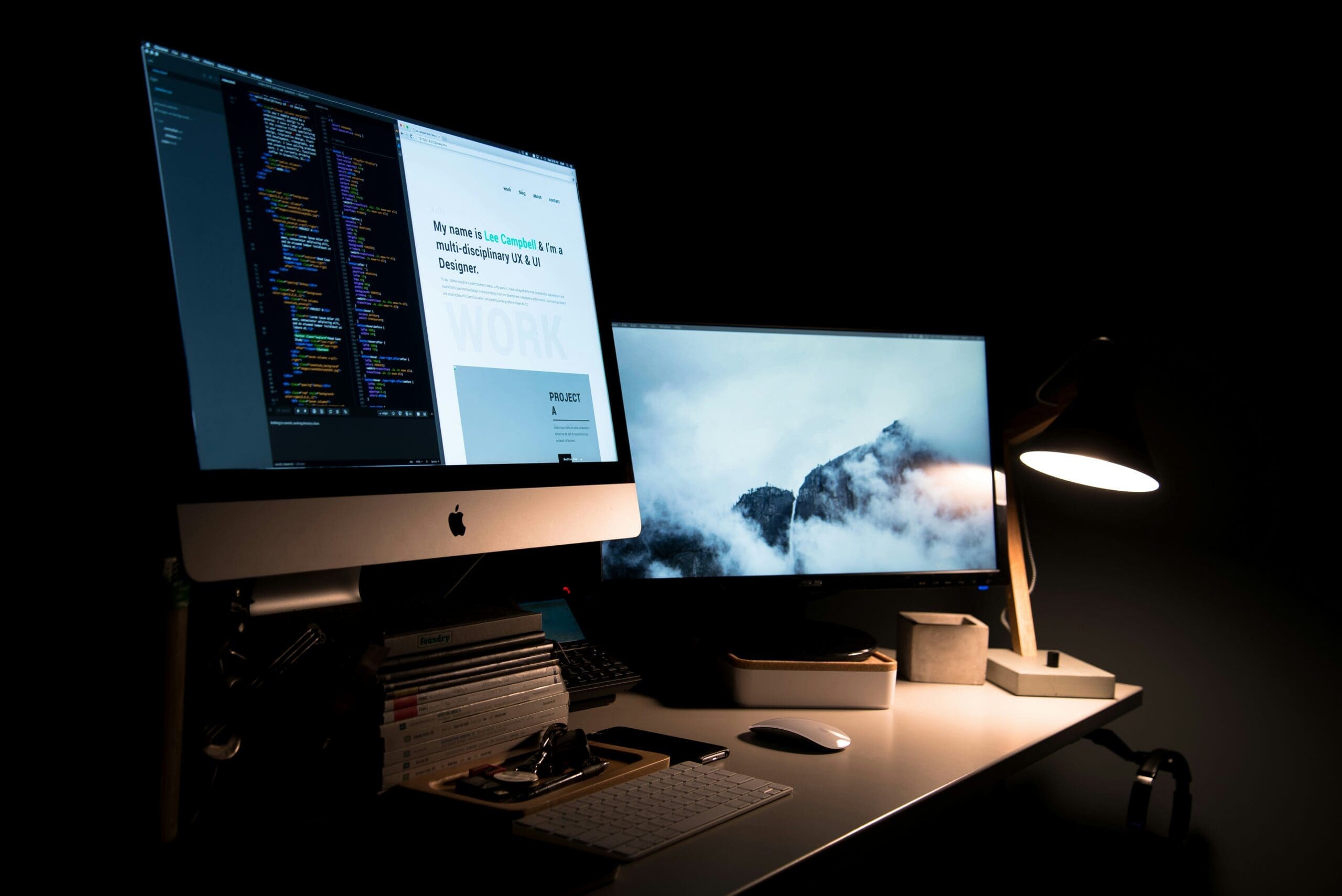 An iMac with a website and development code with a second screen