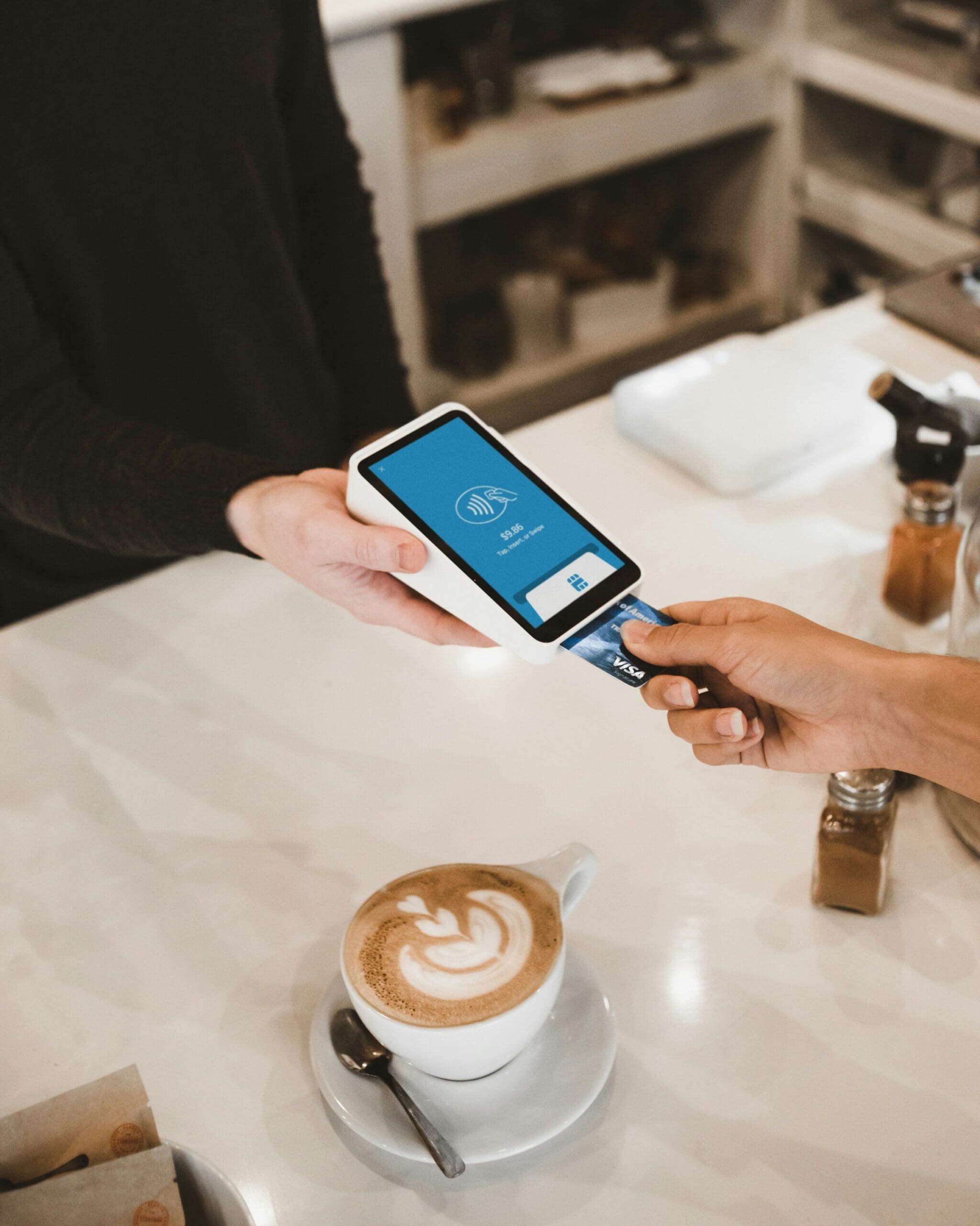 Shot of a customer using their card to pay for a latter at a coffee shop